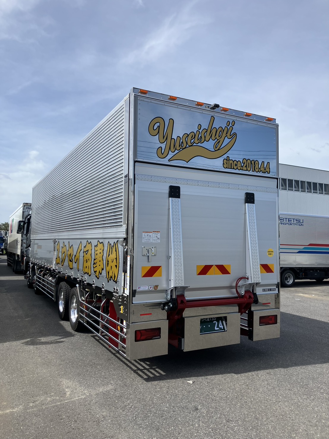 ユウセイ商事の大型トラック後方。ロゴ入りのウイング車