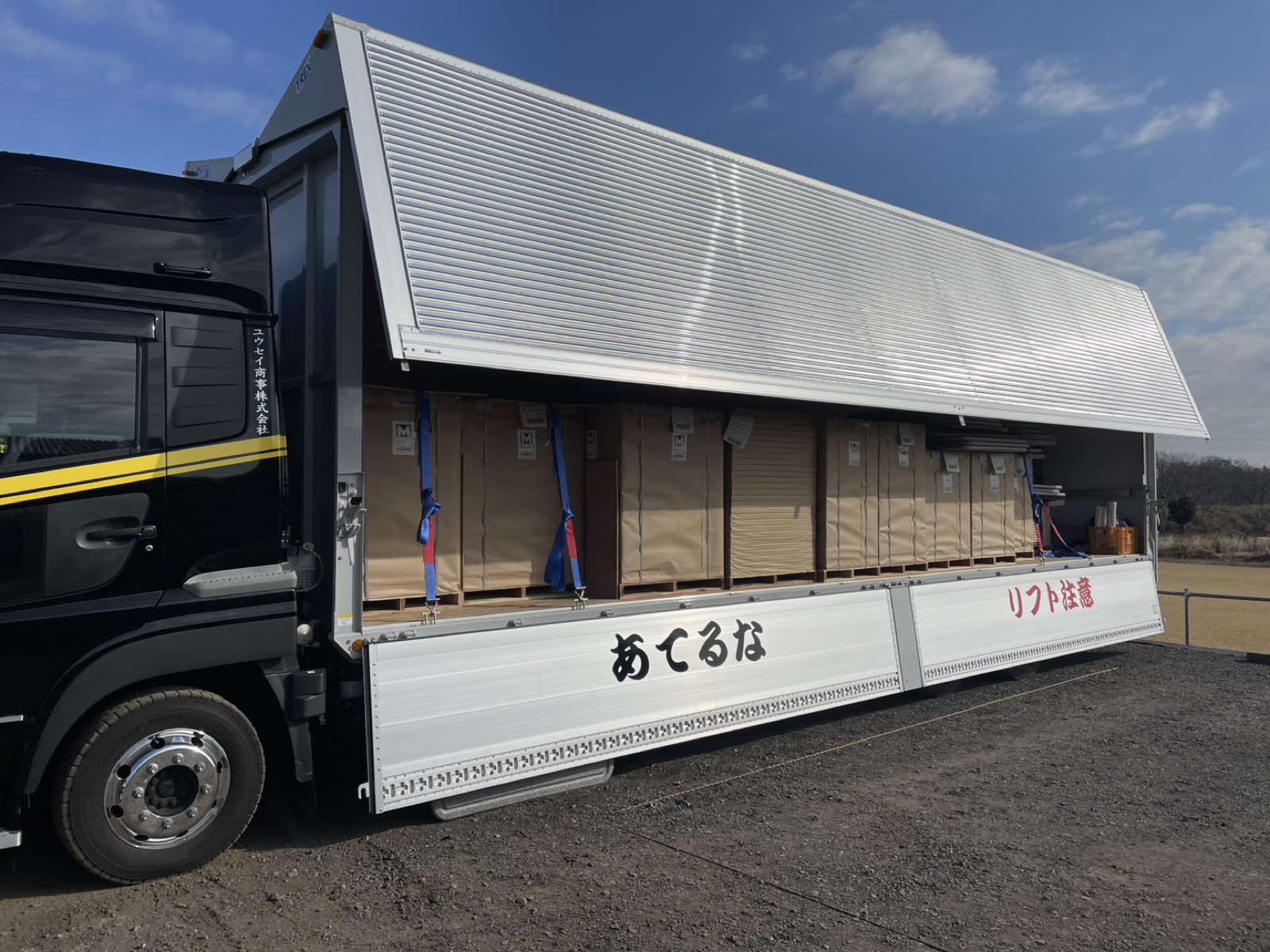 ウイングを開き、荷物を積んだユウセイ商事の大型トラック